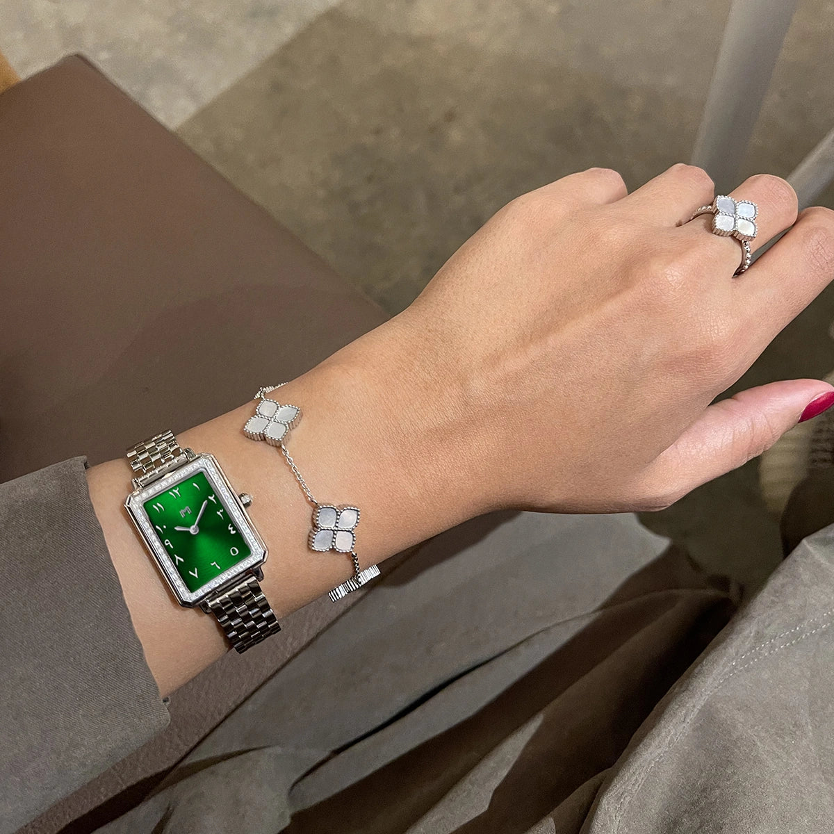 Minimalist green watch with a silver bracelet and ring